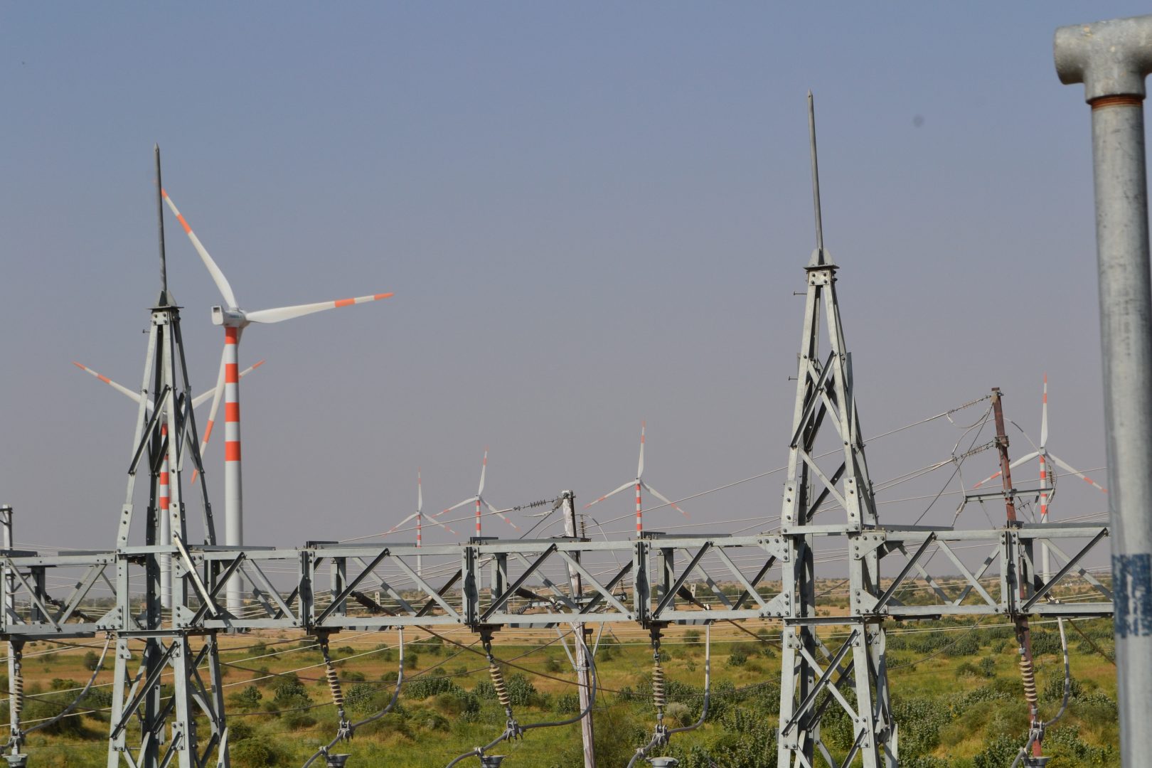 Wind turbine surrounded by power pylons