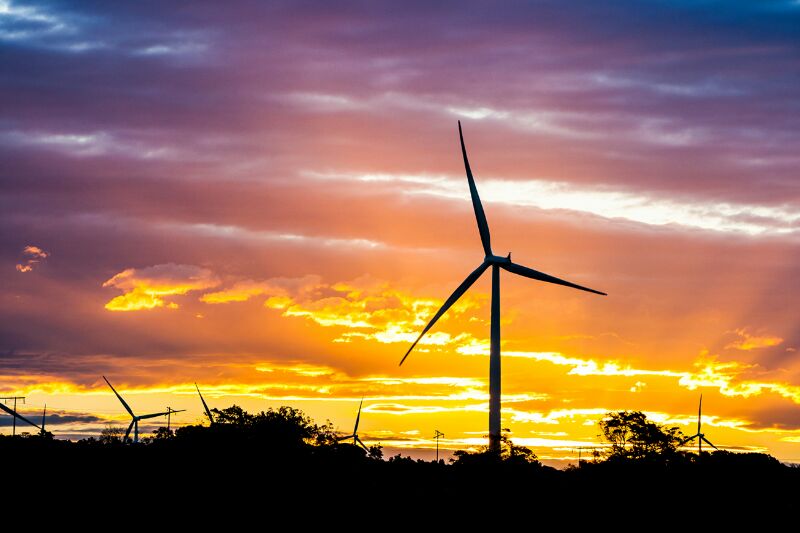 Wind turbine against a sunset sky