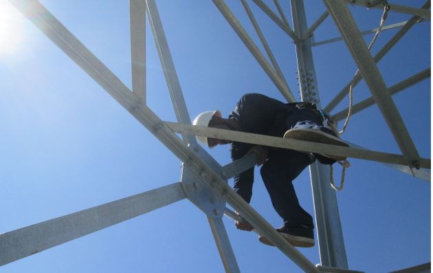 Worker climbs scaffolding to fix something