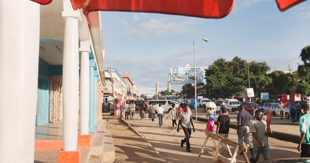 The edges of a red canopy wave in the breeze on a busy street in Lilongwe, Malawi.