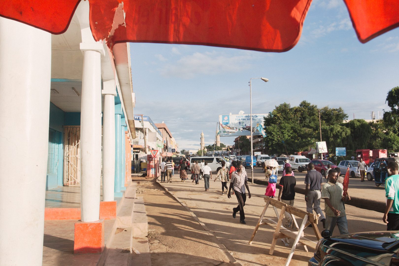 The edges of a red canopy wave in the breeze on a busy street in Lilongwe, Malawi.