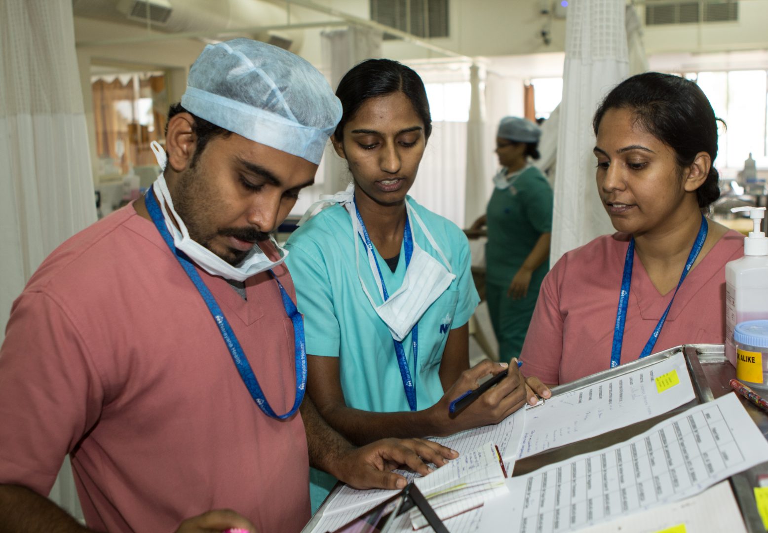 Indian doctors gather round a patients charts