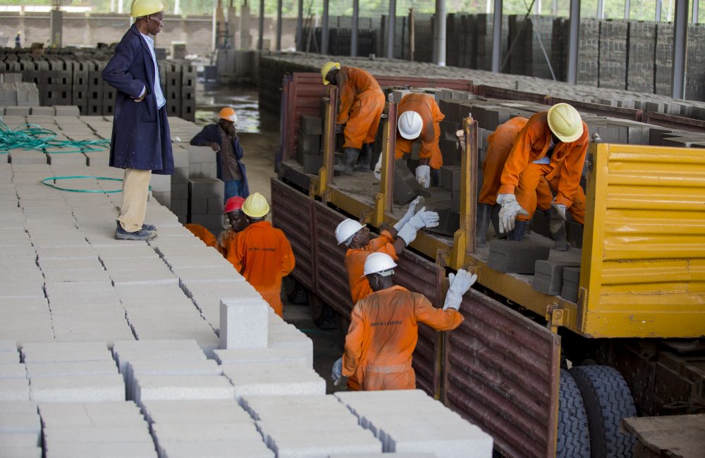 Men unloading cinder blocks from a truck.