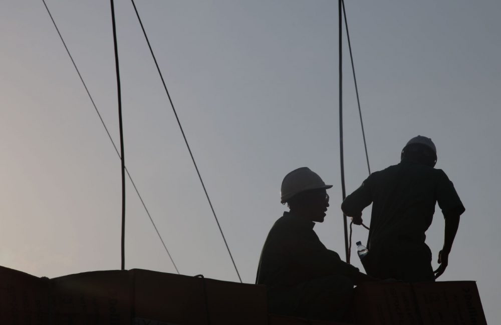 Two silhouettes of men against the sky