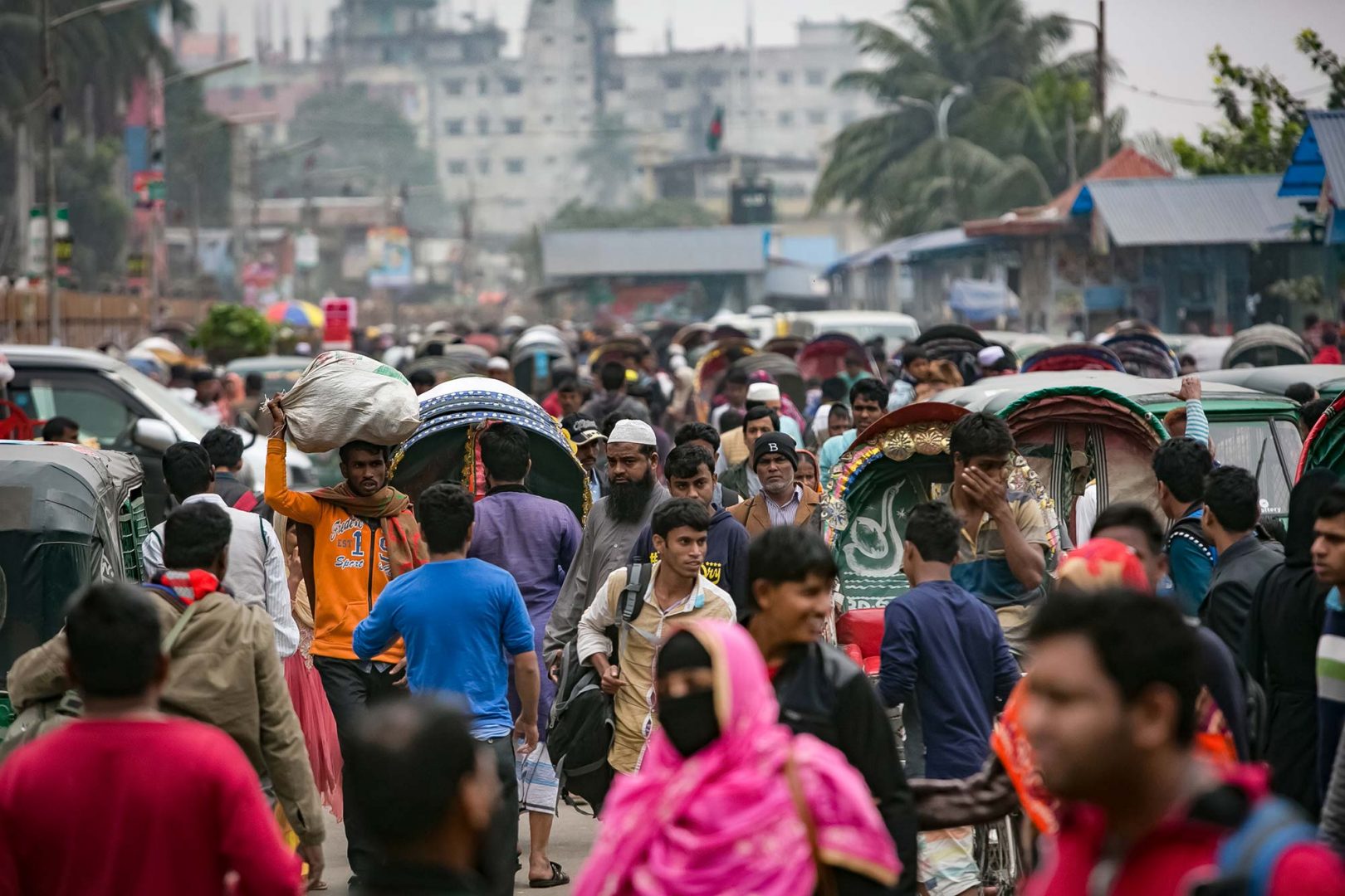 A crowd of people move about a street in India