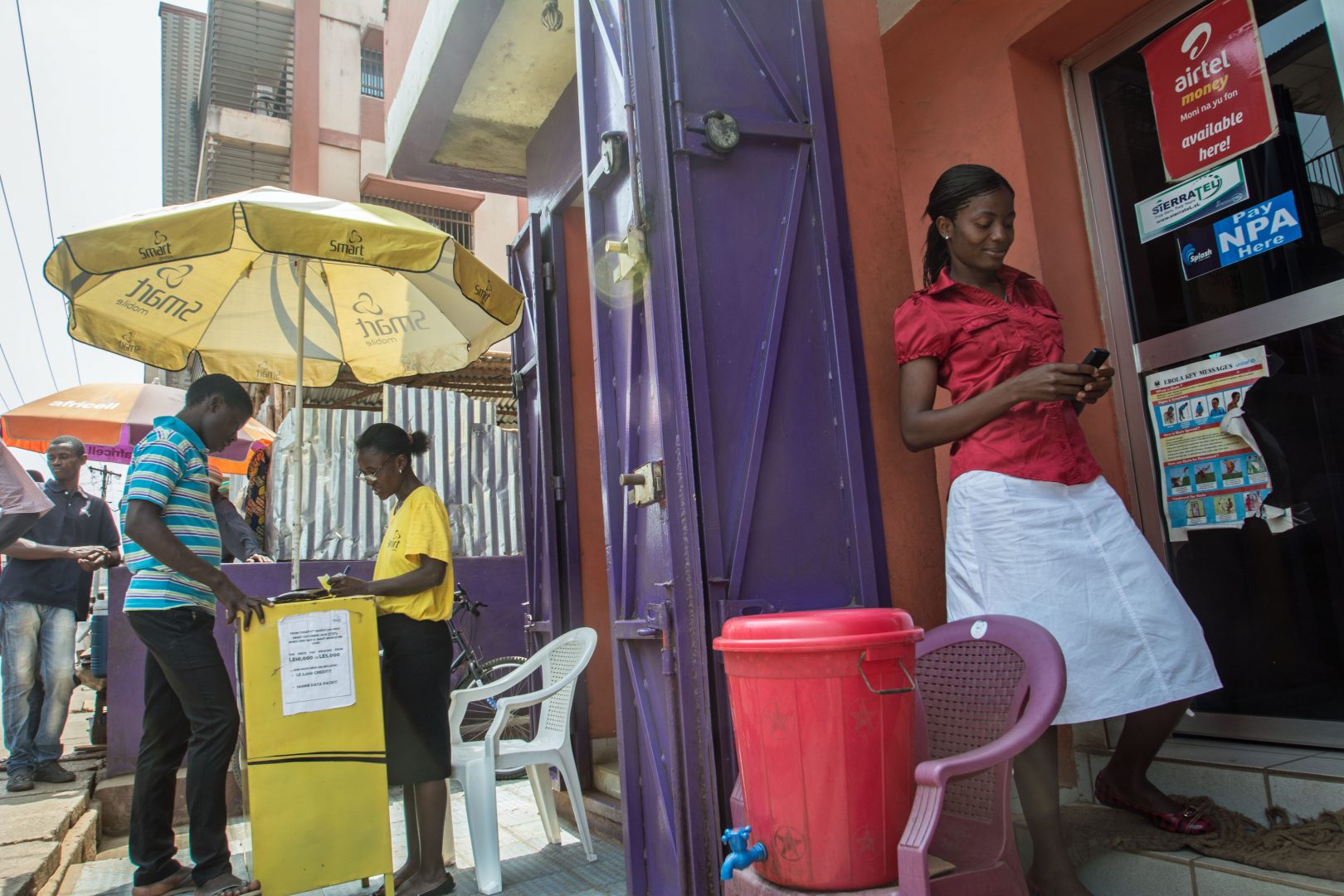 Woman stands outside a brightly coloured shop