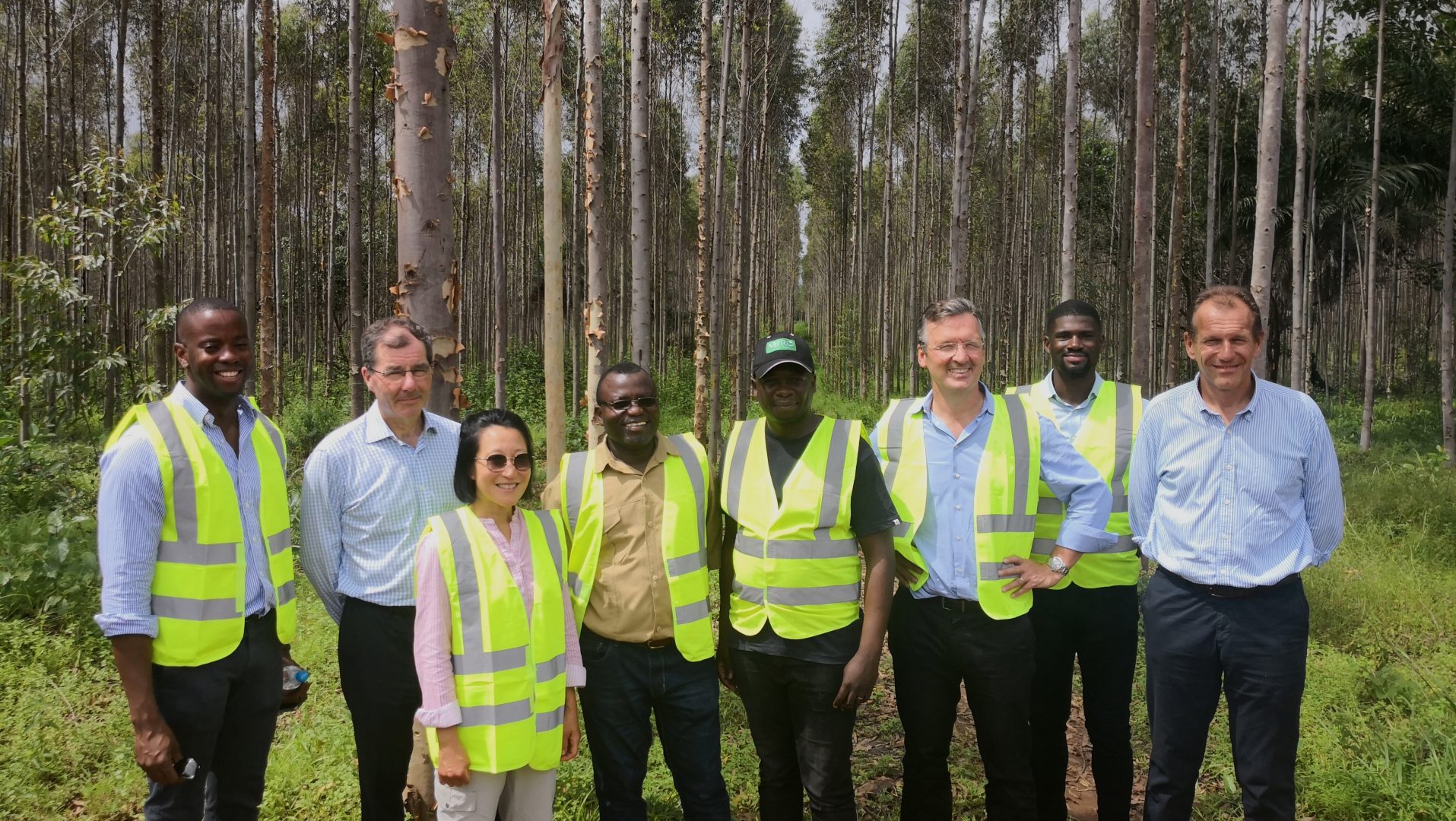 People wearing high vis jackets in front of some trees