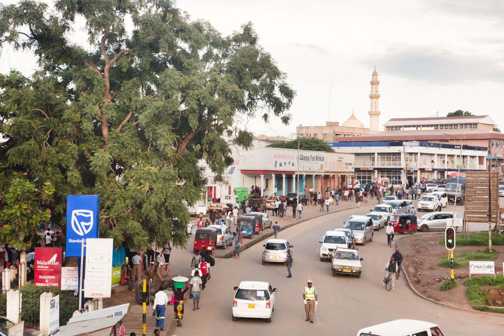 Busy street scene in Malawi with a mosque in the distance